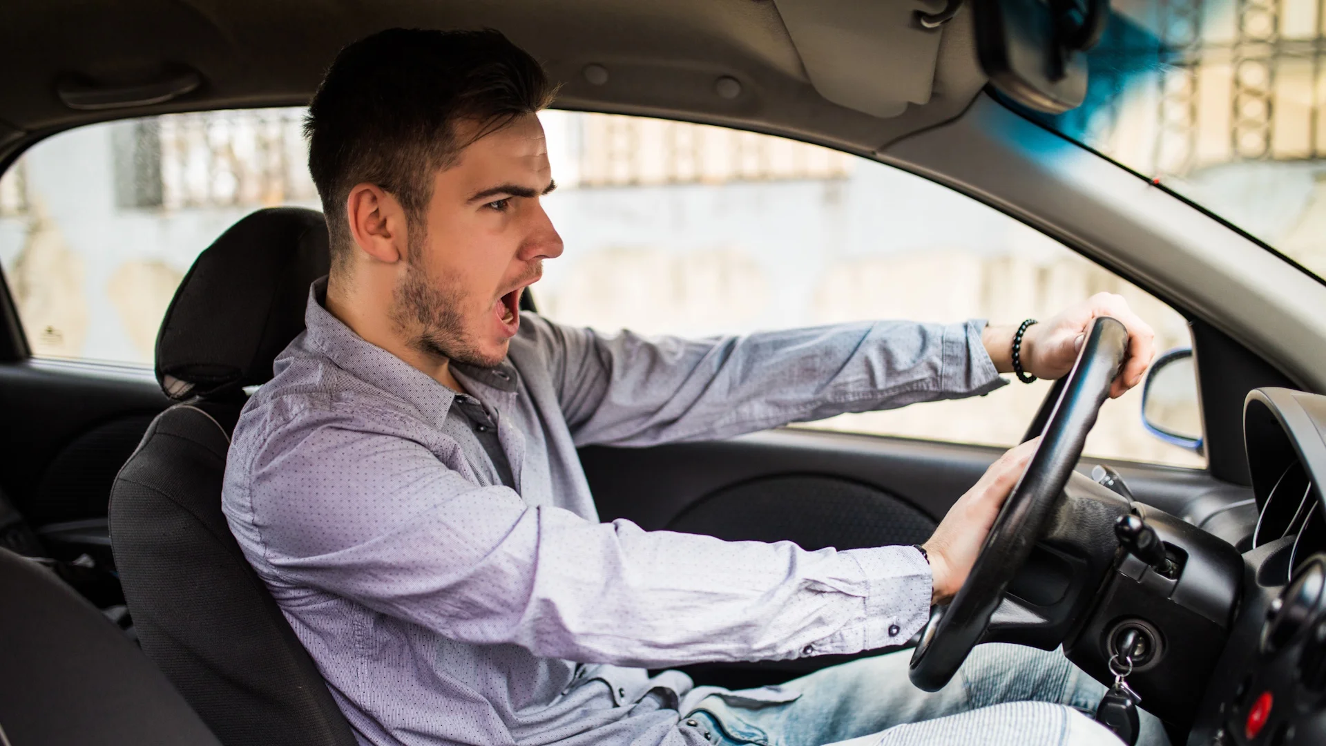 traffic-problems-nice-emotional-man-giving-signal-while-driving-car